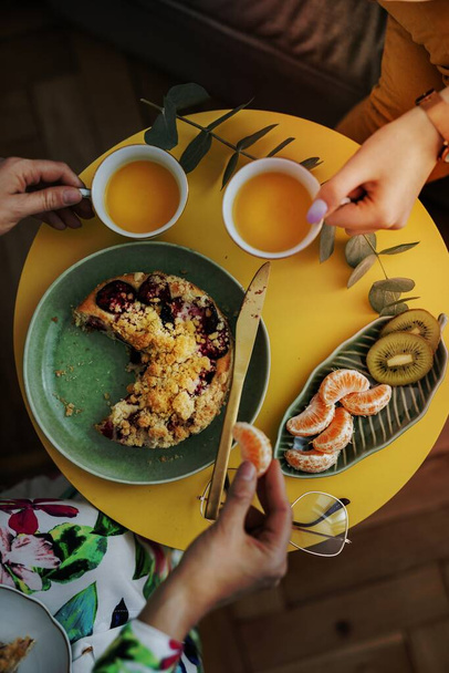 Women having tea with plum crumble pie - 写真・画像