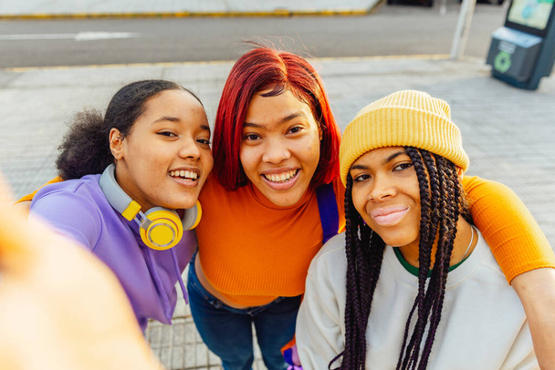 Three latina girls taking a selfie on the street. Women with unretouched skin. celebrating friendship. - Foto, Imagen
