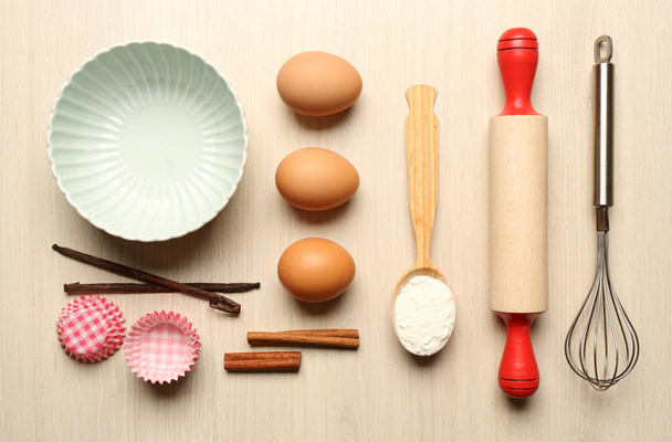 Food ingredients and kitchen utensils for cooking on wooden background - Photo, image