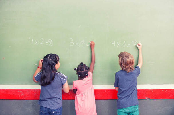 Compañeros de escuela multiétnicos escribiendo matemáticas en pizarra
 - Foto, imagen