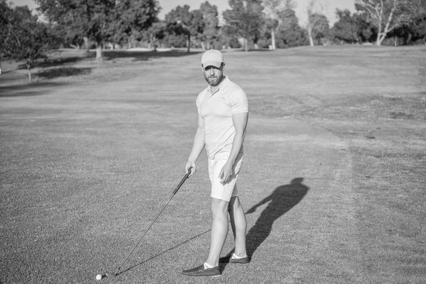 σοβαρός παίκτης του γκολφ στο καπέλο με μπαστούνι του γκολφ, παίκτης του γκολφ. - Φωτογραφία, εικόνα