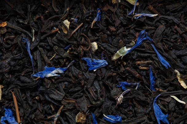 Closeup of black tea with orange, lemon peels and cornflower petals background for design purpose - Valokuva, kuva