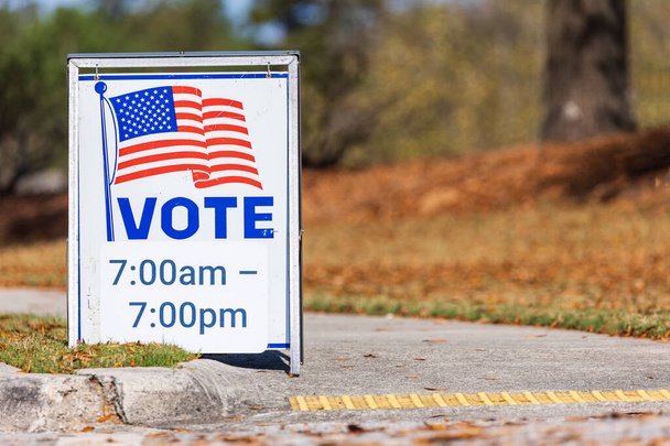 A roadside sign at a voting precinct gives the hours that people can vote. - Foto, imagen
