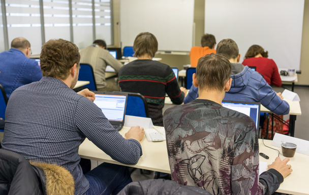 Gente sentada atrás en la clase de entrenamiento informático
 - Foto, imagen