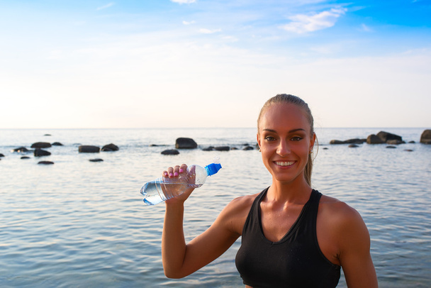 Mladé ženy v sportovní oblečení spočívá s vodou - Fotografie, Obrázek