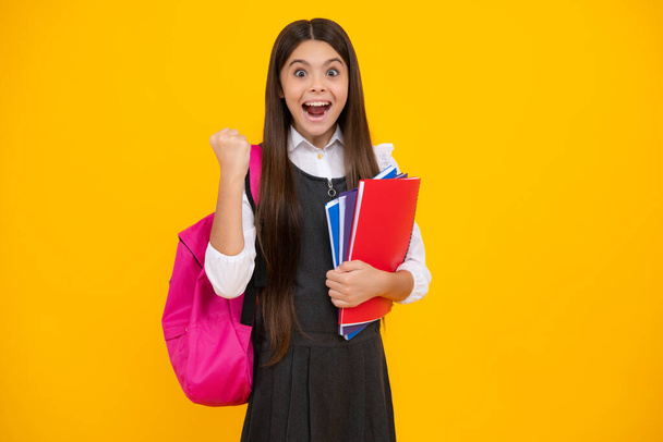 Amazed teen girl. Back to school. School girl student with school bag backpack hold book on isolated studio background. Kids education concept. Excited expression, cheerful and glad - Photo, Image