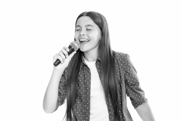 Child girl holding wireless microphone for karaoke singing or talk and speaker on white background isolated with space. Portrait of emotional amazed excited teen girl - Foto, immagini