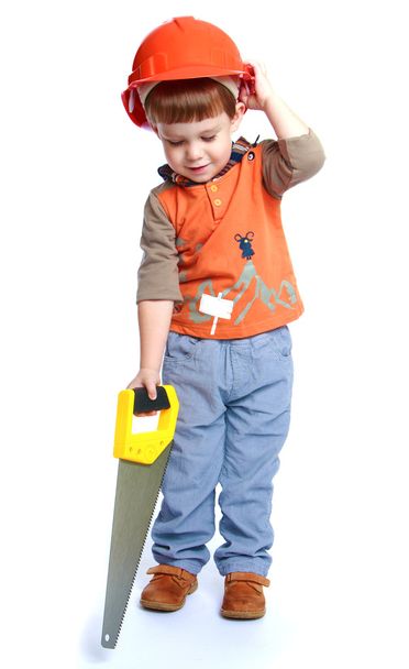 Little boy holding a hacksaw on wood. - Foto, Imagen