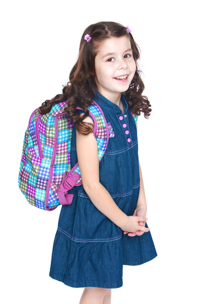 Beautiful little schoolgirl with a knapsack on his shoulders. - Photo, Image