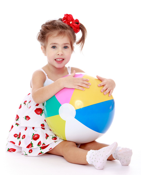 beautiful girl sitting on the floor with a large striped inflata - Photo, Image