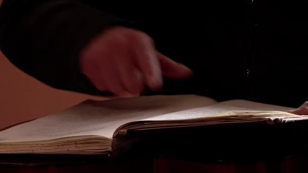 Een man die een oud boek van een notaris leest. Sluiten.  - Video