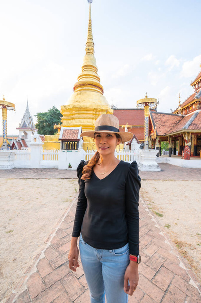 Ασιάτισσα με φόντο το Wat Pong Sanuk, επαρχία Lampang. - Φωτογραφία, εικόνα