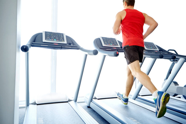 Jogging his way to good health. A handsome young man exercising on a treadmill at the gym - Fotoğraf, Görsel