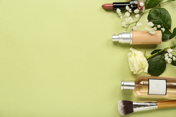 Composición con diferentes cosméticos, pincel de maquillaje y flores sobre fondo verde - Foto, imagen