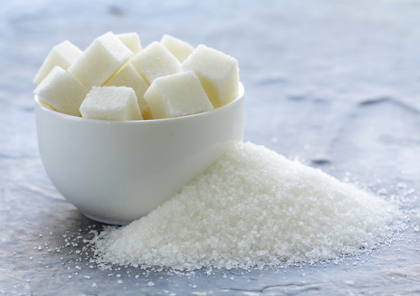 Λευκή κρυσταλλική ζάχαρη και ραφιναρισμένη ζάχαρη σε γκρι φόντο - Φωτογραφία, εικόνα