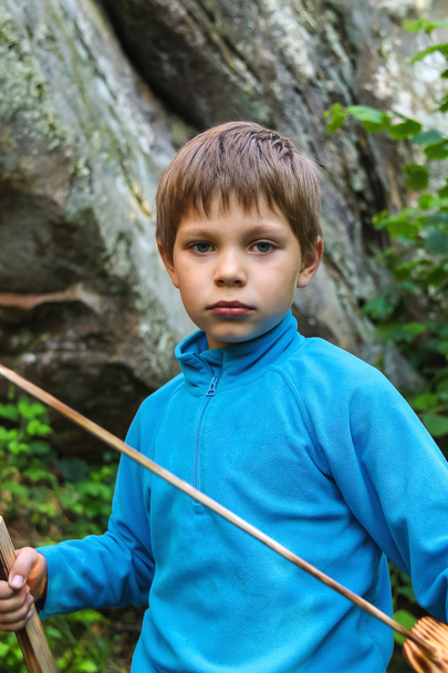 Serious kid with a wooden sword on stone - Photo, Image