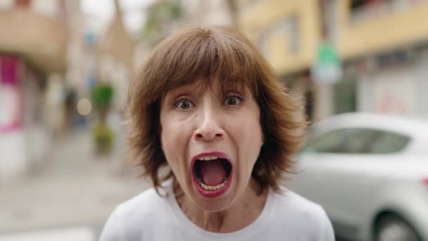 Kobieta w średnim wieku zaskoczona krzykiem na ulicy - Materiał filmowy, wideo