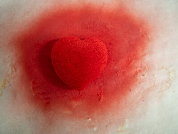 rood fluweel gespoten zoet koekje hartvormig gevuld met caramenl met gouden penseelstreken - Foto, afbeelding