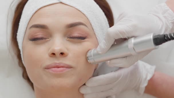 Elettroporazione senza mesoterapia iniettabile. La cosmetologa donna esegue la procedura cosmetica sulla pelle del viso per ridurre le rughe, ripristinare, rigenerare e ringiovanire il viso delle ragazze. Clinica di bellezza - Filmati, video