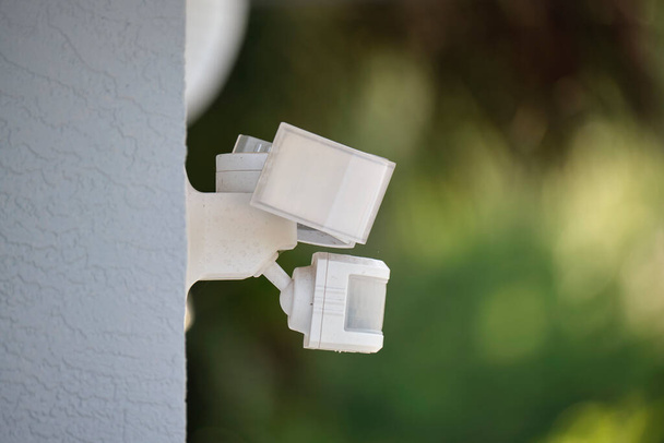 Motion sensor with light detector mounted on exterior wall of private house as part of security system. - Photo, Image