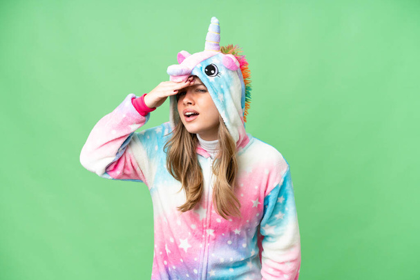 Giovane ragazza con pigiama unicorno su sfondo chiave croma isolato guardando lontano con mano per guardare qualcosa - Foto, immagini