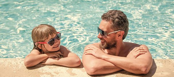 Father and son in swimming pool, banner with copy space. dad and child having fun at pool party. childhood and parenting. father and son. - Photo, Image
