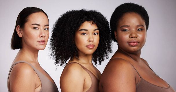 Women, diversity studio portrait and beauty for aesthetic, care or race equality with plus size solidarity. Model, asian and black woman with cosmetics, makeup and wellness with support by background. - Fotografie, Obrázek