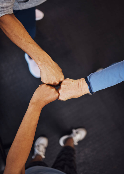 Teamwork, top view and senior women fist bump for team building, motivation and unity. Support, collaboration and group of elderly friends huddle for trust, union or solidarity, goals or targets - Foto, imagen