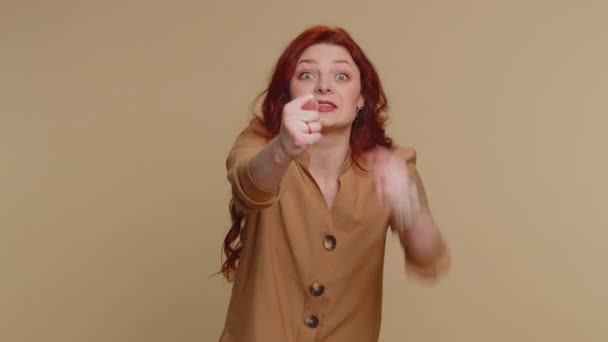 Angry aggressive redhead woman showing fig negative gesture, you dont get it anyway. Rapacious, avaricious, acquisitive. Body language. Refusal fig sign. Greedy avaricious girl on beige background - Imágenes, Vídeo
