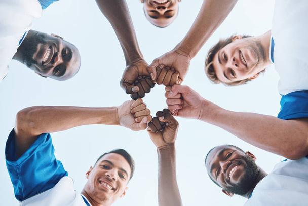 Sports, teamwork and fist bump circle for soccer for support, motivation and community on field. Diversity, team building and low angle portrait of football players ready for game, training and match. - 写真・画像