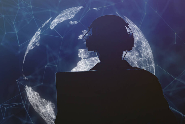 Silhouette of a military man in headphones at a laptop against the background of a digital globe of the earth, contour lighting. Concept: collection of confidential information, surveillance and control of people. - Foto, imagen