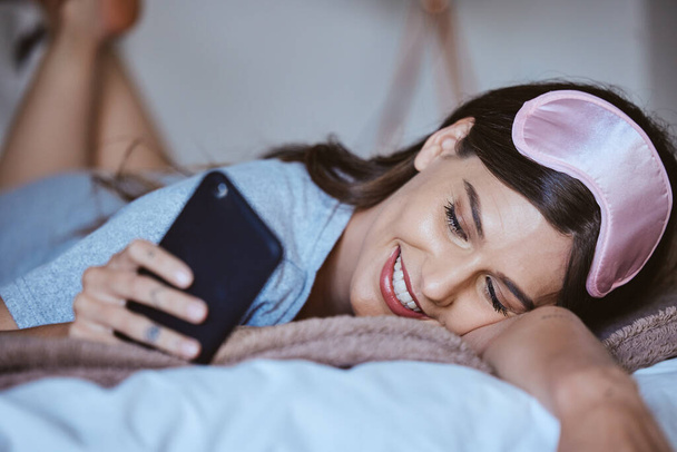 Video call, phone and in love with woman in bedroom for communication, internet and contact. Happy, relax and smile with girl reading text message with technology, online dating and social media. - Fotoğraf, Görsel