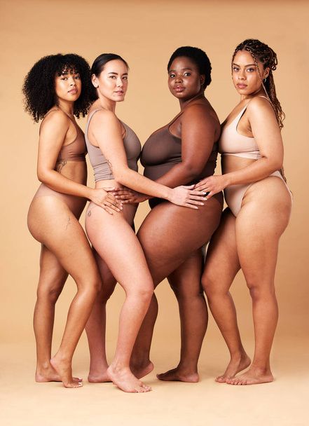 Diversity women, portrait and body positivity friends hug for inclusion, beauty and power. Underwear model group beige background for cellulite legs, pride and motivation for self love or skin care. - 写真・画像