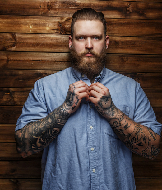 Brutal macho con tatuajes en camiseta
 - Foto, Imagen