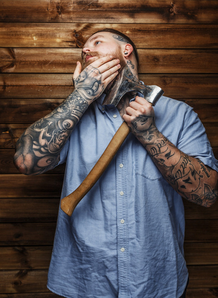 Huge brutal male with tattooes shaves his beard - Photo, Image