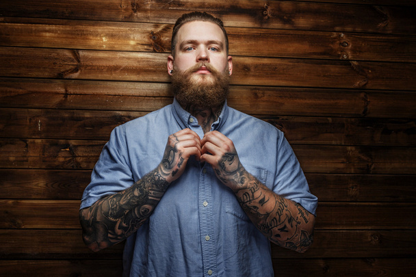 Brutaali mies, jolla on tatuointeja t-paidassa
 - Valokuva, kuva