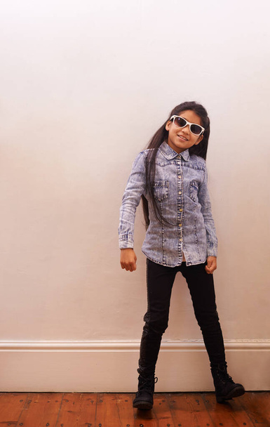 Shes got confidence. Portrait of a cute little girl wearing sunglasses at home - Fotó, kép