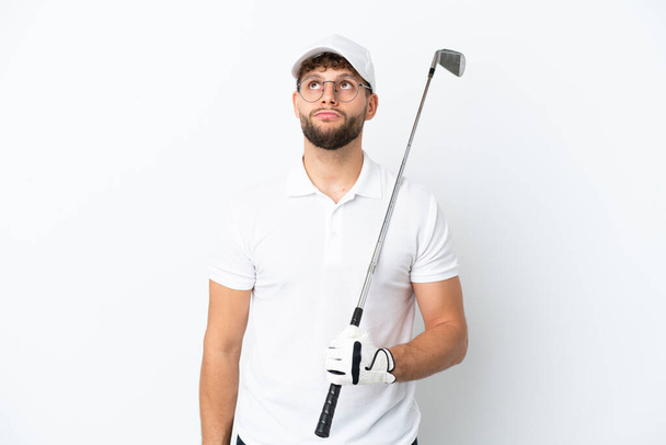 Hezký mladý muž hraje golf izolované na bílém pozadí a vzhlíží - Fotografie, Obrázek