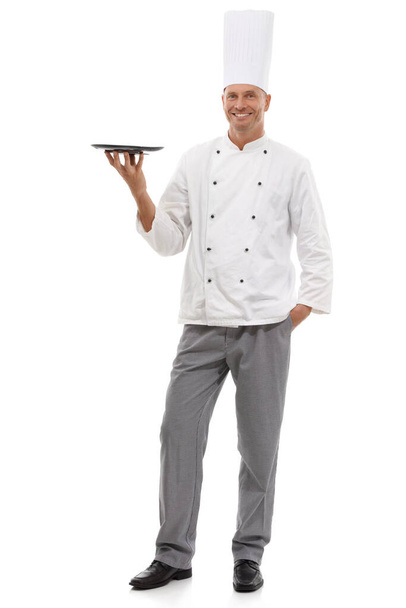 Πορτρέτο του σεφ κρατώντας άδειο δίσκο, μενού ειδικά και χαμόγελο παρουσιάζοντας promo deal ή εστιατόριο τοποθέτηση προϊόντων. Ευτυχισμένος μάγειρας με στολή, μακιγιαρισμένος απομονωμένος σε λευκό φόντο στο στούντιο. - Φωτογραφία, εικόνα