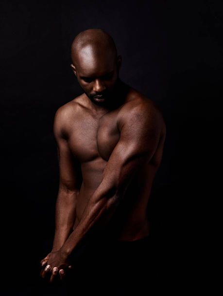 Tunne voima. Studio laukaus lihaksikas mies taivuttaa käsivarren lihaksia - Valokuva, kuva