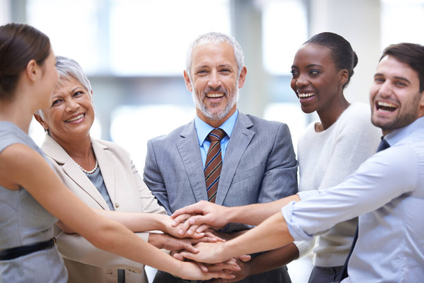 Укрощение бизнеса как команда. a group of businessesspeople putting their hands together in unity - Фото, изображение