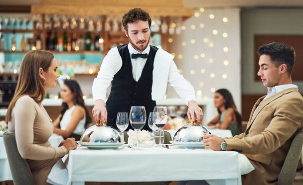 Restaurant, food and valentines day with a couple at a table in celebration of love, romance or marriage together. Wine, night or luxury fine dining with a man and woman celebrating their anniversary. - Foto, imagen