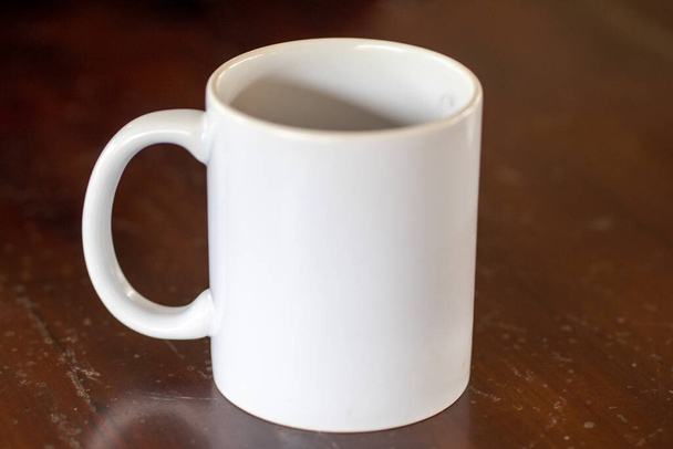 Λευκή κεραμική κούπα καφέ με θολό φόντο από κοντά - Φωτογραφία, εικόνα