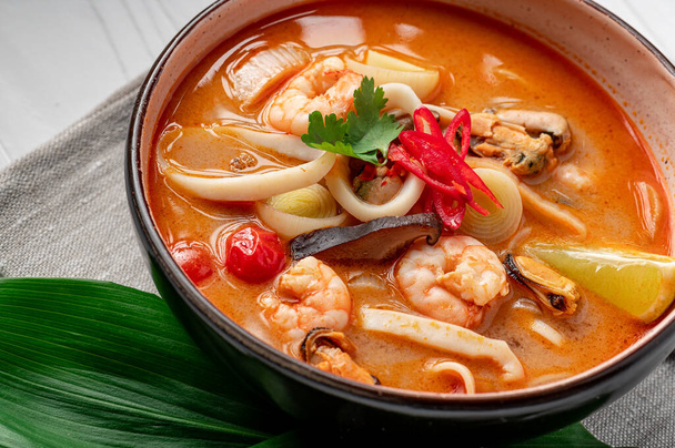 Sopa picante de tom yum asiático com camarão, lula, mexilhões e legumes. Cozinha asiática. Comida deliciosa e saudável. Foto para o menu. - Foto, Imagem