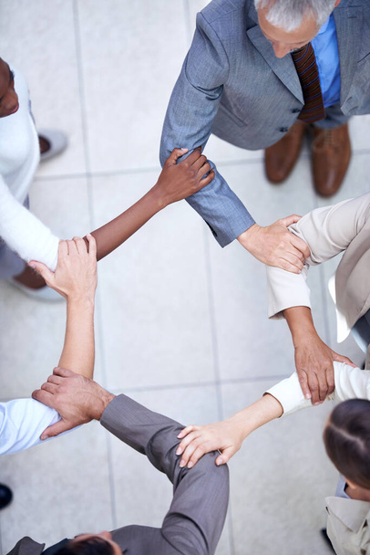 Объединились в бизнесе. a group of business colleagues standing hand in arm - Фото, изображение