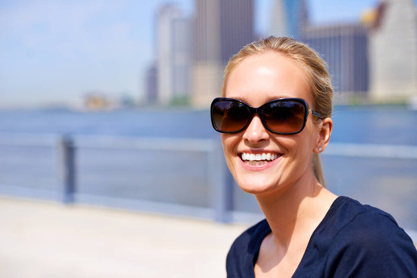Прикрыт на лето. Портрет красивой молодой женщины в солнечных очках, стоящей в городском сиденье - Фото, изображение