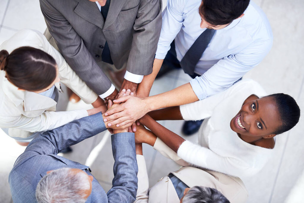 Shes part of a dedicated team. a group of coworkers with their hands in a huddle - Foto, imagen