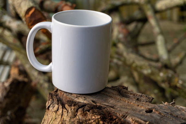 A close-up photo of a white mug in a peaceful park setting, showcasing the beauty and serenity of taking a break surrounded by nature - Fotó, kép