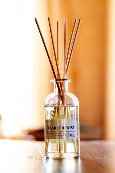 An aroma diffuser with aromatic oil and sticks in the room near the window creates an atmosphere of peace and comfort - 写真・画像