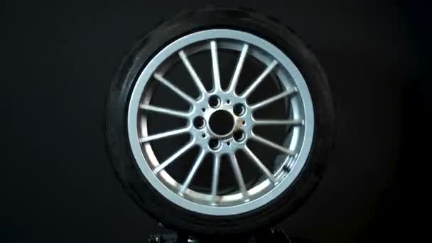 ruedas de coche viejo llantas de titanio video de larga exposición sobre fondo oscuro girar simulación de movimiento - Imágenes, Vídeo